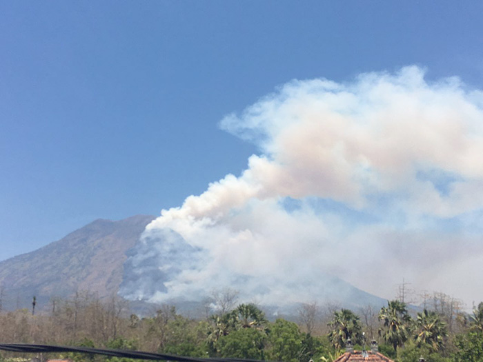 森林火災が起き、煙が上がるアグン山＝１９日、ＢＮＰＢ提供